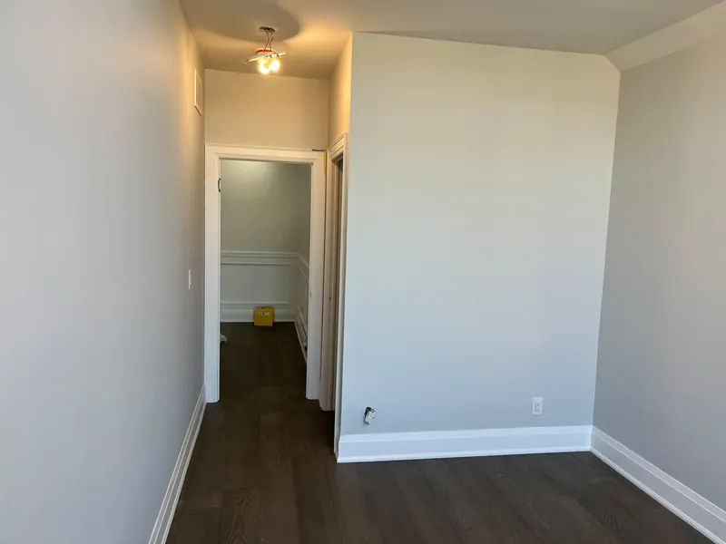 Freshly painted interior walls with white baseboard and door casing